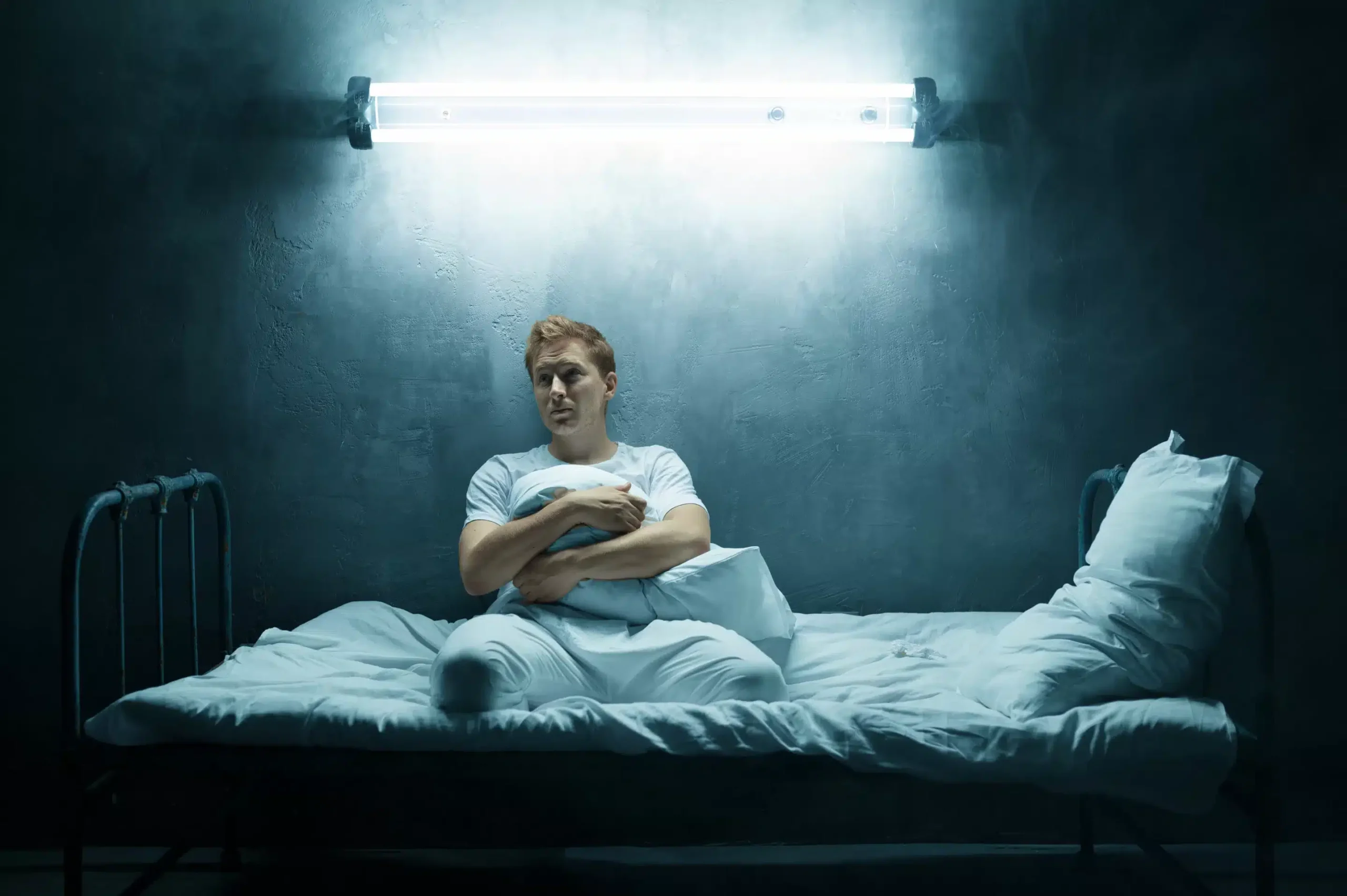 a man sitting on a bed with a pillow